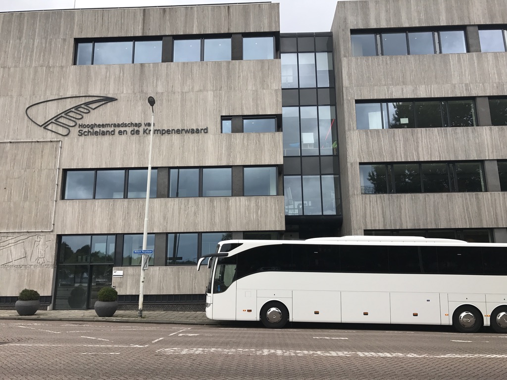 Onze touringcar staat voor bij het gebouw van het Hoogheemraadschap van Schieland en de Krimpenerwaard in Rotterdam langs de Maas. dit voor een tour langs diverse dijken, waterzuiveringsinstallatie's